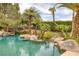 Beautiful lagoon-style pool area with rock features, a bridge, and tropical landscaping at 8130 Cassian Ct, Las Vegas, NV 89129