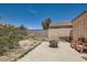 This backyard features desert landscaping and a patio area with chairs, perfect for relaxation at 821 Tollbrook Way, Henderson, NV 89011