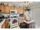 Functional kitchen featuring laminate cabinets, white appliances and an island at 821 Tollbrook Way, Henderson, NV 89011