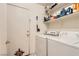 Functional laundry area with stacked appliances and shelving for storage, adjacent to the side entry door at 821 Tollbrook Way, Henderson, NV 89011