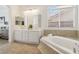 Bright bathroom features a soaking tub, tiled flooring, and dual sinks at 8714 Las Posas Ave, Las Vegas, NV 89147