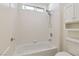 Neat bathroom featuring a bathtub with white tiles and modern fixtures at 8714 Las Posas Ave, Las Vegas, NV 89147