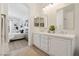 Bright bathroom with double sinks and gold framed mirrors adjacent to bedroom at 8714 Las Posas Ave, Las Vegas, NV 89147