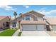 Two-story home featuring a three-car garage, tile roof, desert landscaping, and palm trees on a sunny day at 8714 Las Posas Ave, Las Vegas, NV 89147