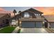 Two-story home with a three-car garage, tile roof, desert landscaping, and palm trees silhouetted by an orange sunset at 8714 Las Posas Ave, Las Vegas, NV 89147