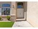 Close up view of a home's double front doors with brick accents and a well-maintained lawn at 8714 Las Posas Ave, Las Vegas, NV 89147