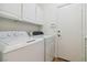 Clean laundry room with washer and dryer, storage cabinets, and a convenient access door at 8714 Las Posas Ave, Las Vegas, NV 89147