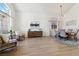 Open-concept living and dining room with hardwood floors, modern light fixture, and large windows at 8714 Las Posas Ave, Las Vegas, NV 89147