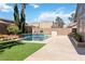 Inviting pool area with well-kept artificial turf and attractive landscaping for relaxation at 8714 Las Posas Ave, Las Vegas, NV 89147