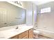 Bright bathroom with a large mirror, wood cabinet, white tiled shower and tub at 8725 Red Rio Dr # 203, Las Vegas, NV 89128