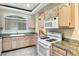 Bright kitchen with tile floors, granite counters, white appliances, and a breakfast bar at 8725 Red Rio Dr # 203, Las Vegas, NV 89128