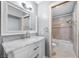 Bathroom featuring a marble countertop vanity, large mirror, and tiled shower with tub at 8932 Antioch Way, Las Vegas, NV 89117