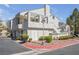 Attractive condo featuring a charming stucco exterior, second floor balcony, and well-manicured rock landscaping at 8932 Antioch Way, Las Vegas, NV 89117