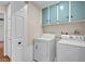 This functional laundry room includes a washer, dryer, and storage cabinets at 8932 Antioch Way, Las Vegas, NV 89117