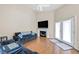Comfortable living room with wood floors, high ceiling, fireplace, and French door access to balcony at 8932 Antioch Way, Las Vegas, NV 89117