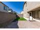 This backyard has a brick patio, a small patch of green grass, and a block wall for privacy at 9239 Albus Hills Ave, Las Vegas, NV 89143