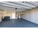 Spacious three car garage with epoxy floors, storage shelves, and a couch at 9239 Albus Hills Ave, Las Vegas, NV 89143