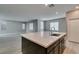 Bright, open kitchen area features a large island with bar seating, modern fixtures, and an adjacent living area at 9239 Albus Hills Ave, Las Vegas, NV 89143