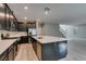 This open kitchen features dark cabinets, stainless steel appliances, a large island with counter seating and gray tile flooring at 9239 Albus Hills Ave, Las Vegas, NV 89143