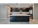 Contemporary kitchen with dark cabinetry, stainless steel appliances, large island with quartz countertops, and tile flooring at 9239 Albus Hills Ave, Las Vegas, NV 89143