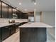 Spacious kitchen offers dark wood cabinetry, stainless appliances, a large island with white countertops, and recessed lighting at 9239 Albus Hills Ave, Las Vegas, NV 89143