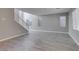 Spacious living room with wood-style tile flooring and lots of natural light from many windows at 9239 Albus Hills Ave, Las Vegas, NV 89143