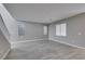 Spacious living room with gray walls, wood-look tile flooring, and multiple windows at 9239 Albus Hills Ave, Las Vegas, NV 89143