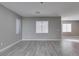 Bright living room with modern gray walls, wood-look tile flooring, and large windows at 9239 Albus Hills Ave, Las Vegas, NV 89143