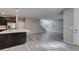 Spacious open concept living area, seamlessly combining the kitchen, living room, and staircase, features gray wood-look tile at 9239 Albus Hills Ave, Las Vegas, NV 89143