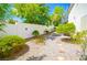 Low-maintenance backyard with gravel, a privacy wall, and mature landscaping for added serenity at 9408 Amber Valley Ln, Las Vegas, NV 89134