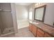 Bathroom showcasing a separate shower, tub, single sink vanity with wood cabinets, and neutral tile flooring at 9408 Amber Valley Ln, Las Vegas, NV 89134