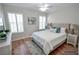 Staged bedroom with hardwood floors, two windows with blinds, and ceiling fan at 9408 Amber Valley Ln, Las Vegas, NV 89134
