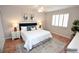 Staged bedroom with hardwood floors, two windows with blinds, and ceiling fan at 9408 Amber Valley Ln, Las Vegas, NV 89134