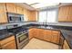 Well-lit kitchen with stainless steel appliances, granite countertops and wooden cabinets at 9408 Amber Valley Ln, Las Vegas, NV 89134
