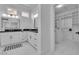Bright bathroom featuring dual vanities, black countertops, and an adjacent walk-in closet at 9513 Villa Ridge Dr, Las Vegas, NV 89134