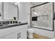 Elegant bathroom featuring a glass-enclosed shower over tub, modern fixtures, and a sleek white vanity at 9513 Villa Ridge Dr, Las Vegas, NV 89134