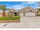 Charming home exterior featuring a well-manicured lawn, desert landscaping, and a three-car garage at 9513 Villa Ridge Dr, Las Vegas, NV 89134