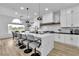Modern white kitchen featuring an island with waterfall countertop and pendant lighting at 9513 Villa Ridge Dr, Las Vegas, NV 89134