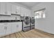 Modern laundry room featuring new appliances, a utility sink, and white cabinets for ample storage space at 9513 Villa Ridge Dr, Las Vegas, NV 89134