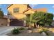 Charming two-story home with a brown two car garage, desert landscaping, and large palm tree at , North Las Vegas, NV 89031