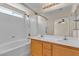 Bathroom featuring a bath and shower combination, a double sink vanity, and a large mirror at 10791 Silver Lace Ln, Las Vegas, NV 89135