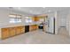 Kitchen view with tile floors, stainless steel fridge, wood cabinets, and ample countertop space at 10791 Silver Lace Ln, Las Vegas, NV 89135