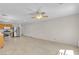 Spacious living room featuring tile floors, a ceiling fan, and stainless steel kitchen appliances at 10791 Silver Lace Ln, Las Vegas, NV 89135