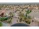 A sprawling community view featuring a beautiful home with a well-manicured lawn, mature palm trees, and a paved driveway at 11158 Antonine Wall Ct, Las Vegas, NV 89141