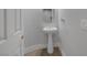 Charming pedestal sink with oval mirror and neutral decor in this well-lit half bathroom at 11158 Antonine Wall Ct, Las Vegas, NV 89141
