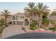 Stunning two-story home featuring a paved driveway, mature palm trees, and a welcoming front entrance with an arched portico at 11158 Antonine Wall Ct, Las Vegas, NV 89141