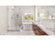 Well-lit bathroom with a glass shower, soaking tub, and wooden cabinets at 11398 Belmont Lake Dr # 104, Las Vegas, NV 89135