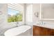 Bright bathroom featuring a standalone tub, large window, and modern fixtures at 11398 Belmont Lake Dr # 104, Las Vegas, NV 89135