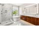 Modern bathroom featuring marble walls, a glass-enclosed shower, soaking tub, and wood cabinets at 11398 Belmont Lake Dr # 104, Las Vegas, NV 89135