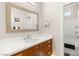 Bright bathroom with wood vanity, white countertop, and large mirror at 11398 Belmont Lake Dr # 104, Las Vegas, NV 89135